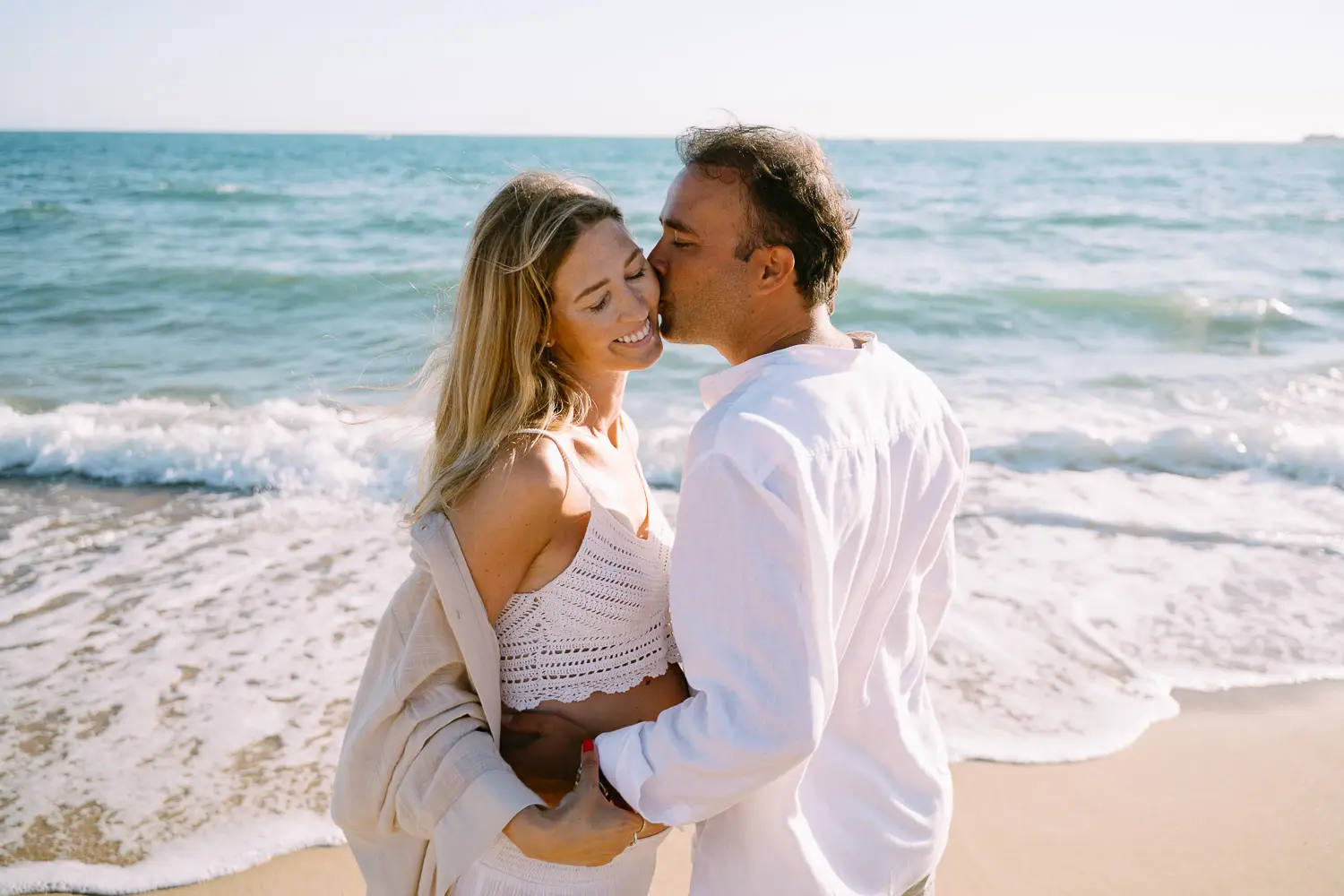 Pareja esperando a su primer hijo en la playa