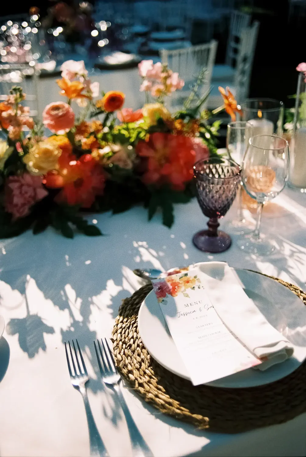 Mesa de boda con flores y un menú escrito a mano en una boda en Sotogrande, fotografiada en película