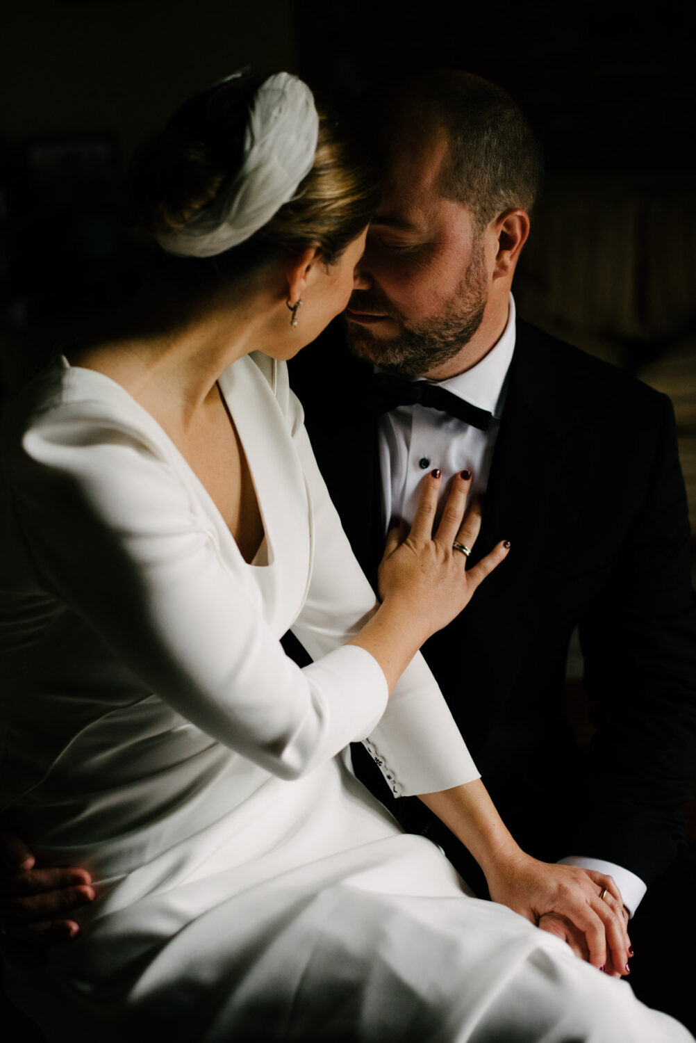 Novia apoyando la mano en el pecho del novio con luz suave en una casa palacio de Jerez